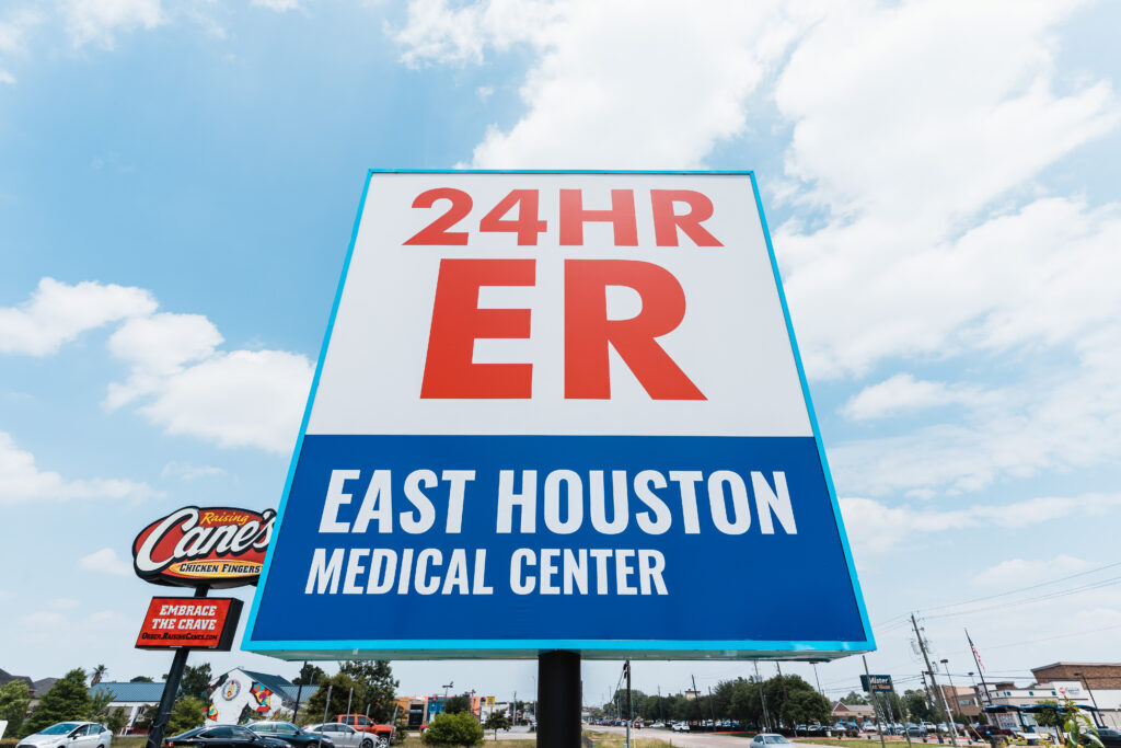 Outdoor signage showing 24/7 emergency outpatient care in Houston, TX.