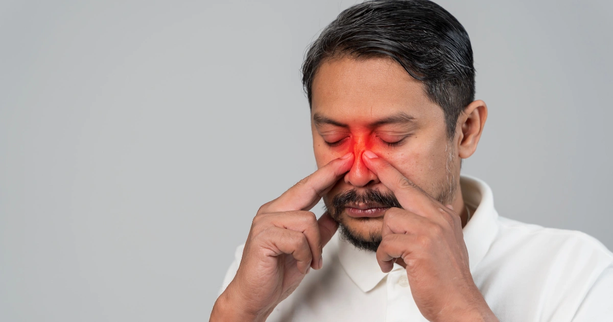 Man with contagious sinus infection touching nose