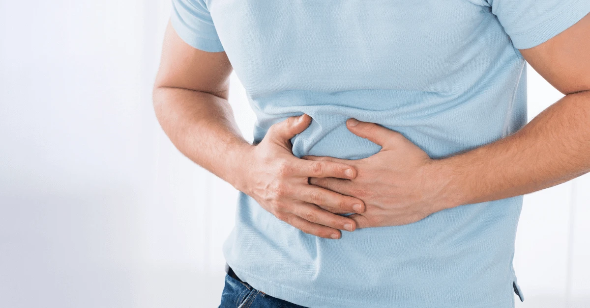 Person clutching their stomach in pain.